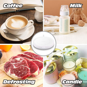 A white mug filled with latte art sits on a sleek white heating coaster, with steam rising from the cup.