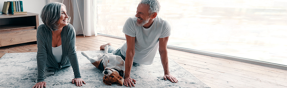 Senior couple exercising at home with their dog