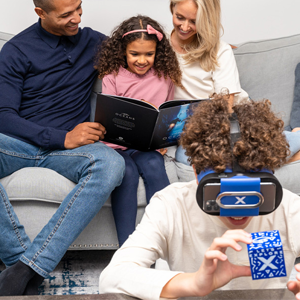 male child enjoying the VR headset while parents and sister read through Ocean book in background